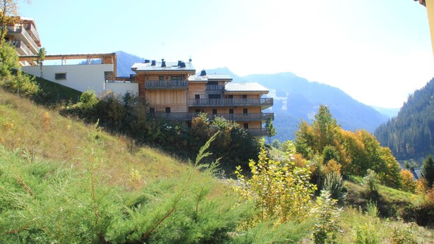 A multi-story building with balconies, surrounded by a mountainous landscape. - Gentianes Gna17 Cosy & Mountain 4 Pers (Chatel)