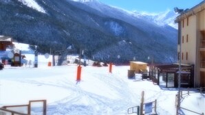 Paisaje montañoso cubierto de nieve con un edificio que tiene un letrero que dice "Restaurant Escalier".