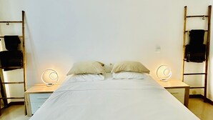 Una stanza semplice e pulita con un letto, due comodini e due mensole a parete.