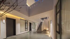 Un interior moderno con una escalera, puertas de cristal y un tragaluz.