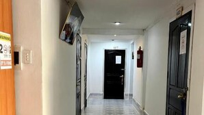 A hotel corridor with a tiled floor, a fire extinguisher, and a door at the end. - Vientianestar  (Vientiane)