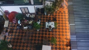 An outdoor seating area with tables and chairs, surrounded by potted plants. - Vientianestar  (Vientiane)