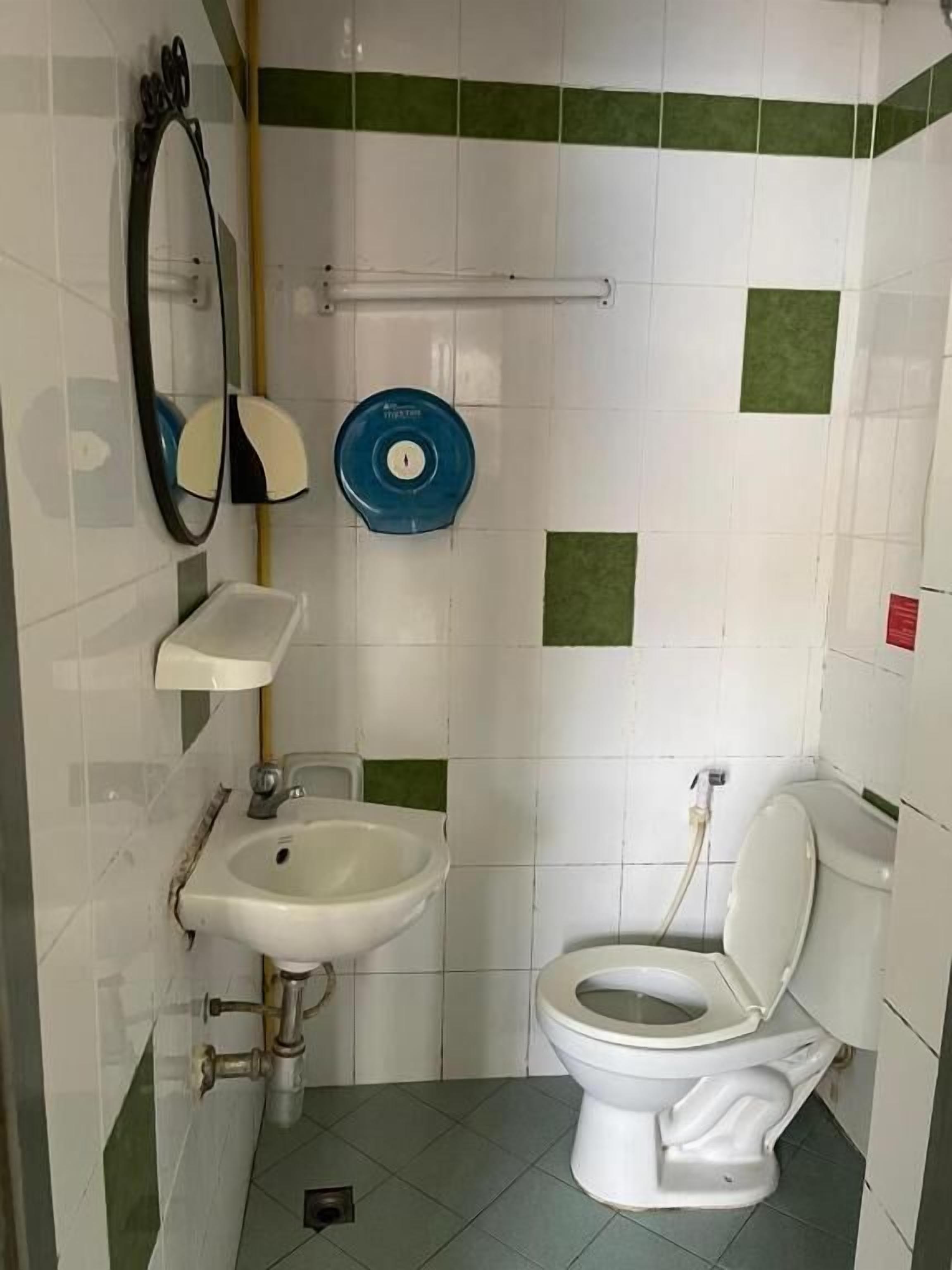 Un baño pequeño con inodoro, lavamanos y espejo.