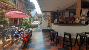 A restaurant with a checkered floor, a red motorcycle, and a red umbrella outside. - Vientianestar  (Vientiane)