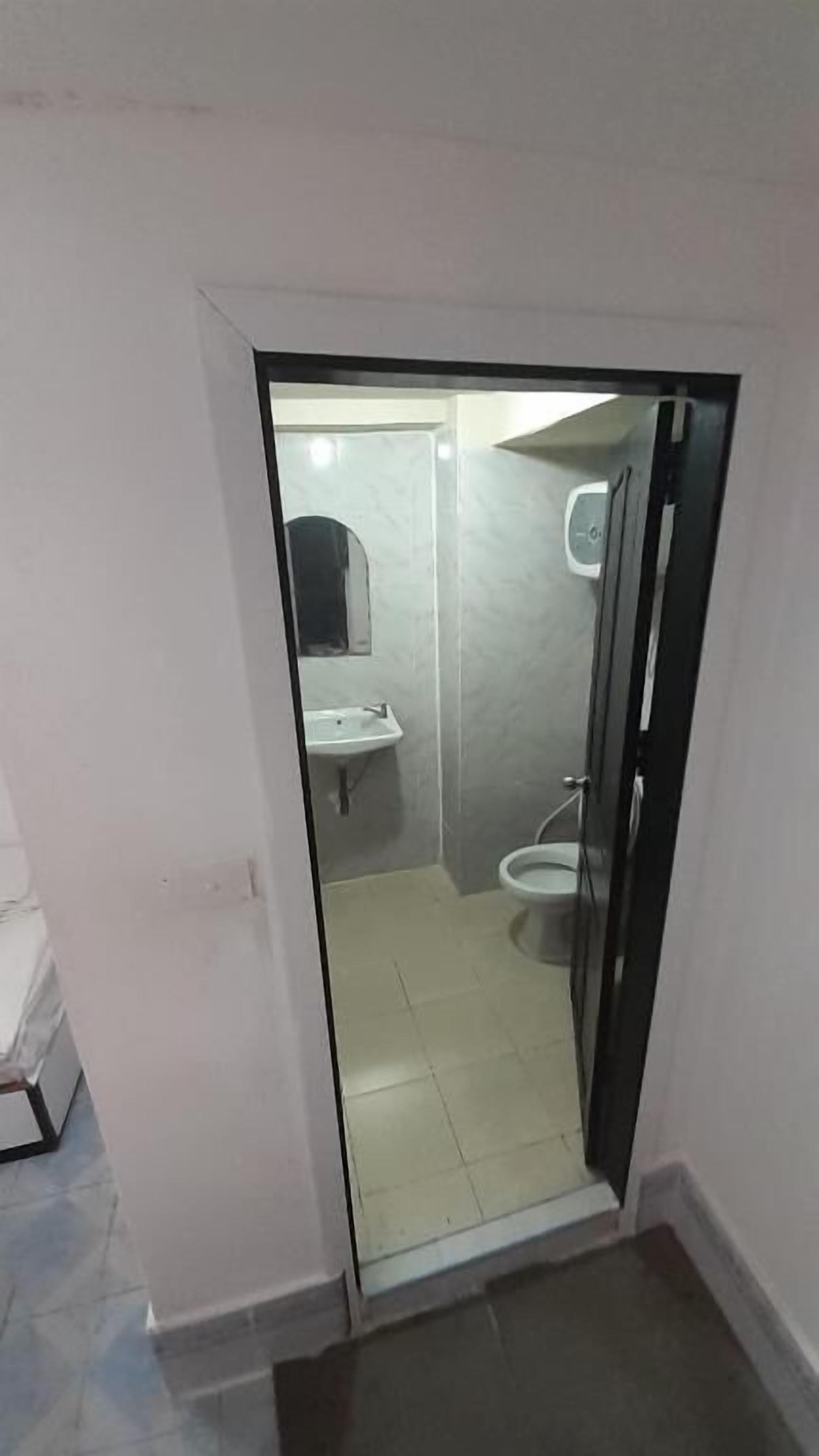 Un baño pequeño y cerrado con inodoro, lavamanos y espejo.