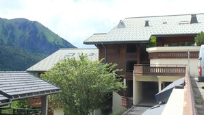 A building with a sloped roof, a balcony, and a mountain in the background. - Barbessine Bbb11 SUN & Chair Lift 5 Pers (Chatel)