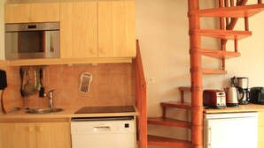 A compact kitchen with wooden cabinets, a dishwasher, a microwave, and a coffee maker. - Barbessine Bbb11 SUN & Chair Lift 5 Pers (Chatel)