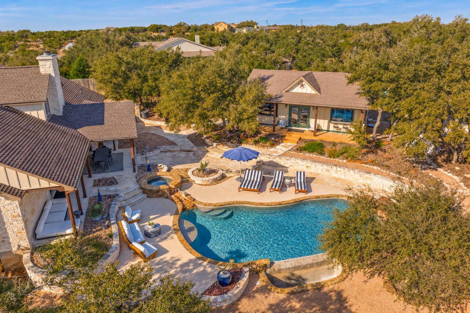 Private pool and hot tub between the main house and casita, surrounded by poolside seating and Hill Country views