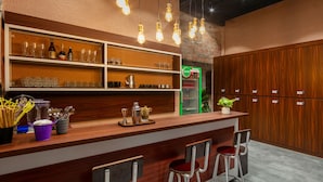 Eine Barbereich mit Holzböden, Barhocker und einer Minibar.