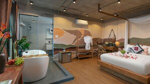 Ein modernes Hotelzimmer mit einem großen Bett, einem Schreibtisch, einer Duschkabine und einer kleinen Sitzecke.