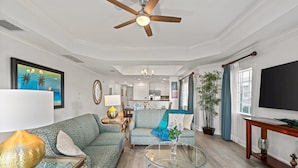 Un salon spacieux avec un canapé, une table basse et un ventilateur de plafond.