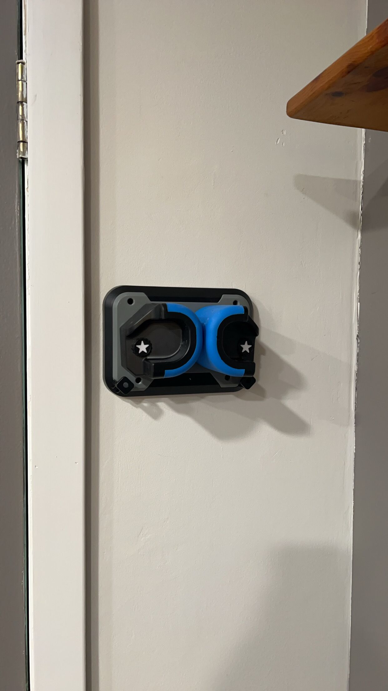Une porte blanche avec un objet noir et bleu fixé dessus.