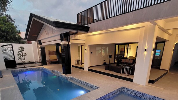 A modern outdoor pool area with a flat roof and a balcony overlooking the pool. - Jay's villa 2 Friendship (Angeles)