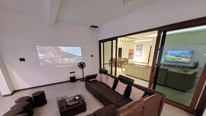 A modern living room with a sectional sofa, a coffee table, and a projector screen displaying a scenic image. - Jay's villa 2 Friendship (Angeles)