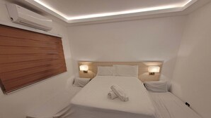A hotel room with a single bed, two bedside lamps, a wooden headboard, a window with blinds, and an air conditioning unit. - Jay's villa 2 Friendship (Angeles)