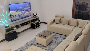 A modern living room with a sectional sofa, a glass coffee table, and a flat-screen TV. - Jay's villa 2 Friendship (Angeles)