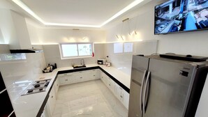 A modern kitchen with a stainless steel refrigerator, a built-in oven, and a large window. - Jay's villa 2 Friendship (Angeles)