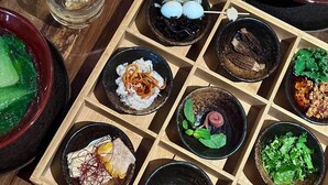 A variety of dishes on a wooden table, including sushi, salad, and other Asian cuisine. - Shanxun Snow Mountain Villa Hotel (Guilin)