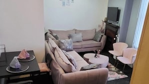 Ein Wohnzimmer mit einer Couch, einem kleinen runden Tisch und zwei Sesseln.