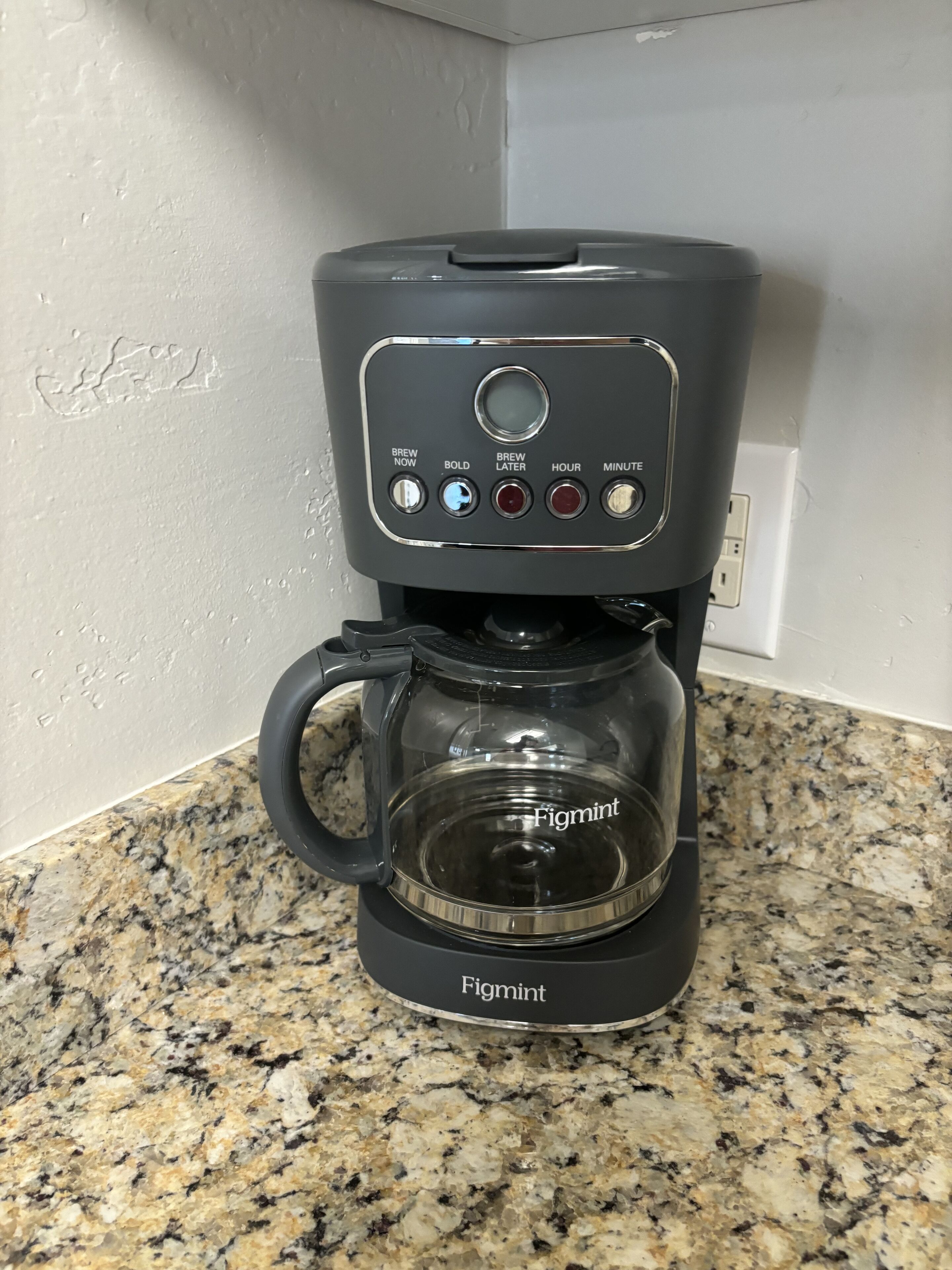 Een koffiezetapparaat met een glazen kan, genaamd 'Figmint', op een granieten aanrecht.
