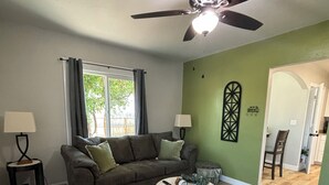 A living room with a ceiling fan, a sofa, a coffee table, and a rug. - Cozy, 1-bedroom apartment with a pulled-out couch, close to all the facilities. (Porterville)