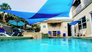 Ein Schwimmbad mit Liegestühlen und Sonnenschirmen.