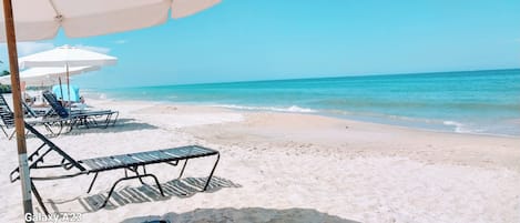 Una playa cerca, sillas reclinables de playa, toallas de playa