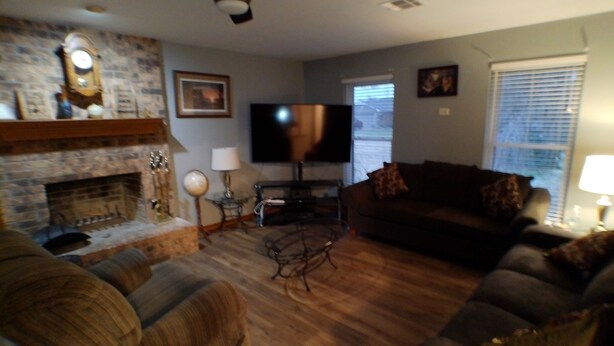 Una sala de estar con chimenea, televisor y sofá.