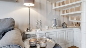 Ein gut beleuchteter Wohnbereich mit einer modernen Lampe, Dekorationen und einem weißen Konsolentisch.