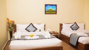 A hotel room with two beds, a painting on the wall, and a vase with flowers on the left side. - RPS Service Apartment (Tiruvannamalai)
