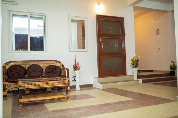 Una habitación con sofá, una puerta y una escalera.