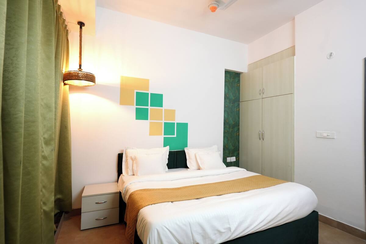 Un dormitorio ordenado con cama, mesita de noche y armario.