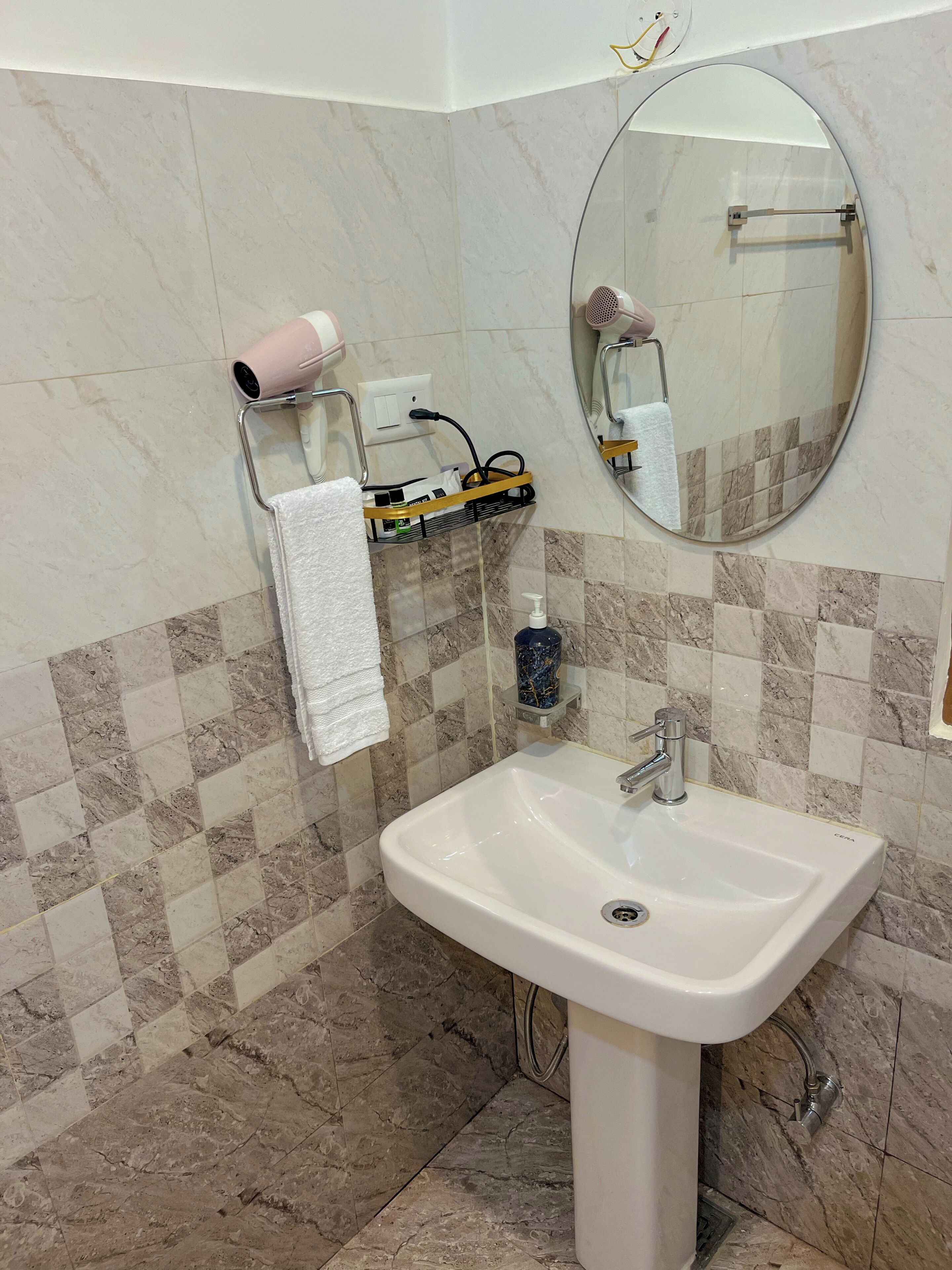 A bathroom with a white sink, a mirror, a towel rack, and a hairdryer.