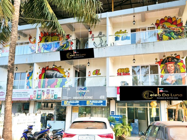 Un edificio de varios pisos con murales coloridos, una clínica dental y un letrero que anuncia el hotel 'Celeb Da Luna'.