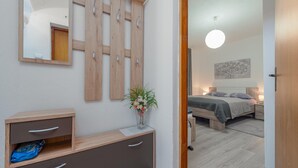 A bedroom with a bed, bedside tables, a hanging light fixture, and a wall-mounted mirror. - 1 bedroom gorgeous apartment in Gracac (Gracac)