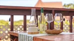 A wooden table with a bottle of wine, a glass, and a candle on a balcony. - Taean Vintage House Pet-friendly Pension (Taean)