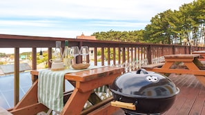 A wooden deck with a barbecue grill, picnic table, and wine glasses. - Taean Vintage House Pet-friendly Pension (Taean)