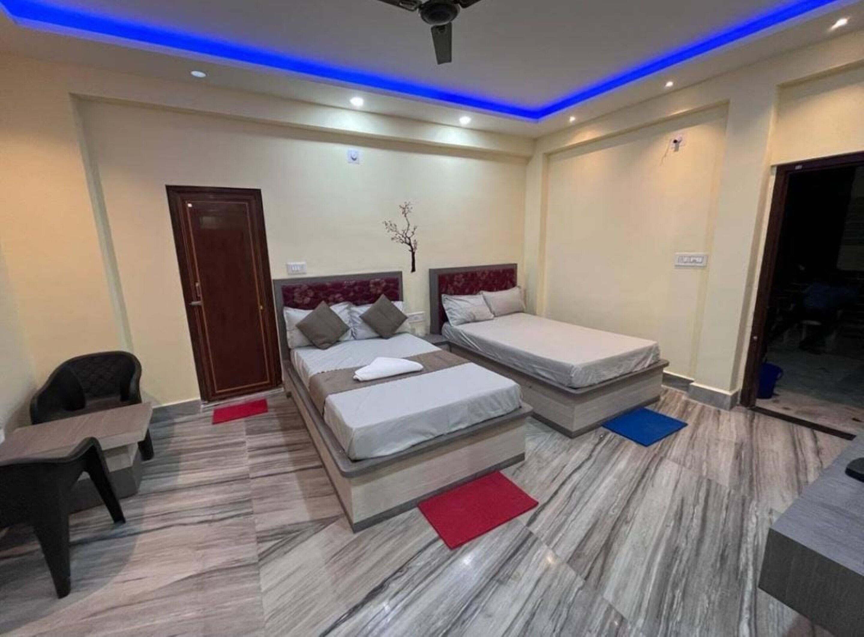 A hotel room with two beds, a desk, and a chair.