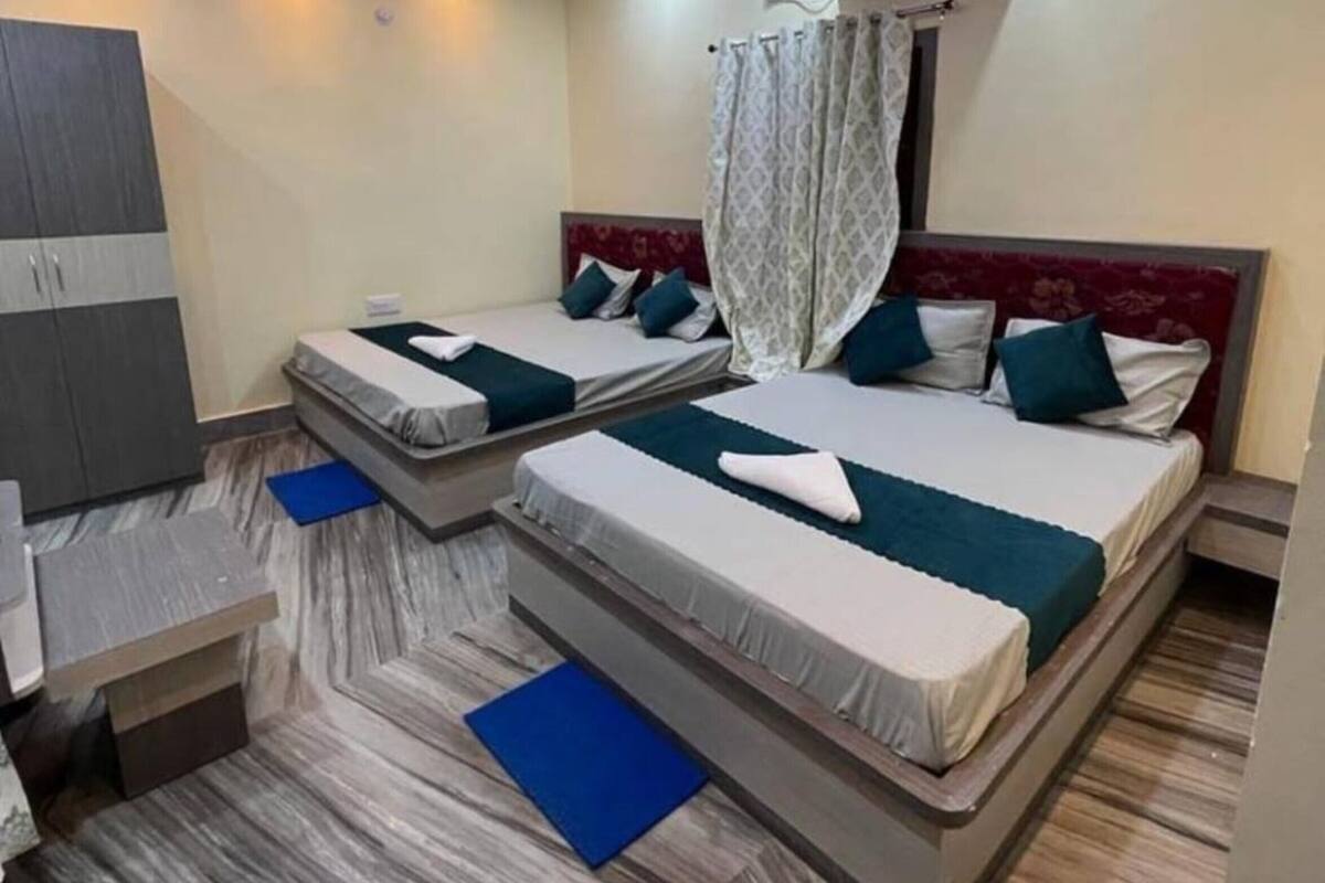 Une chambre d’hôtel moderne équipée de deux lits, d’une armoire, d’un ventilateur de plafond et d’un appareil de climatisation.