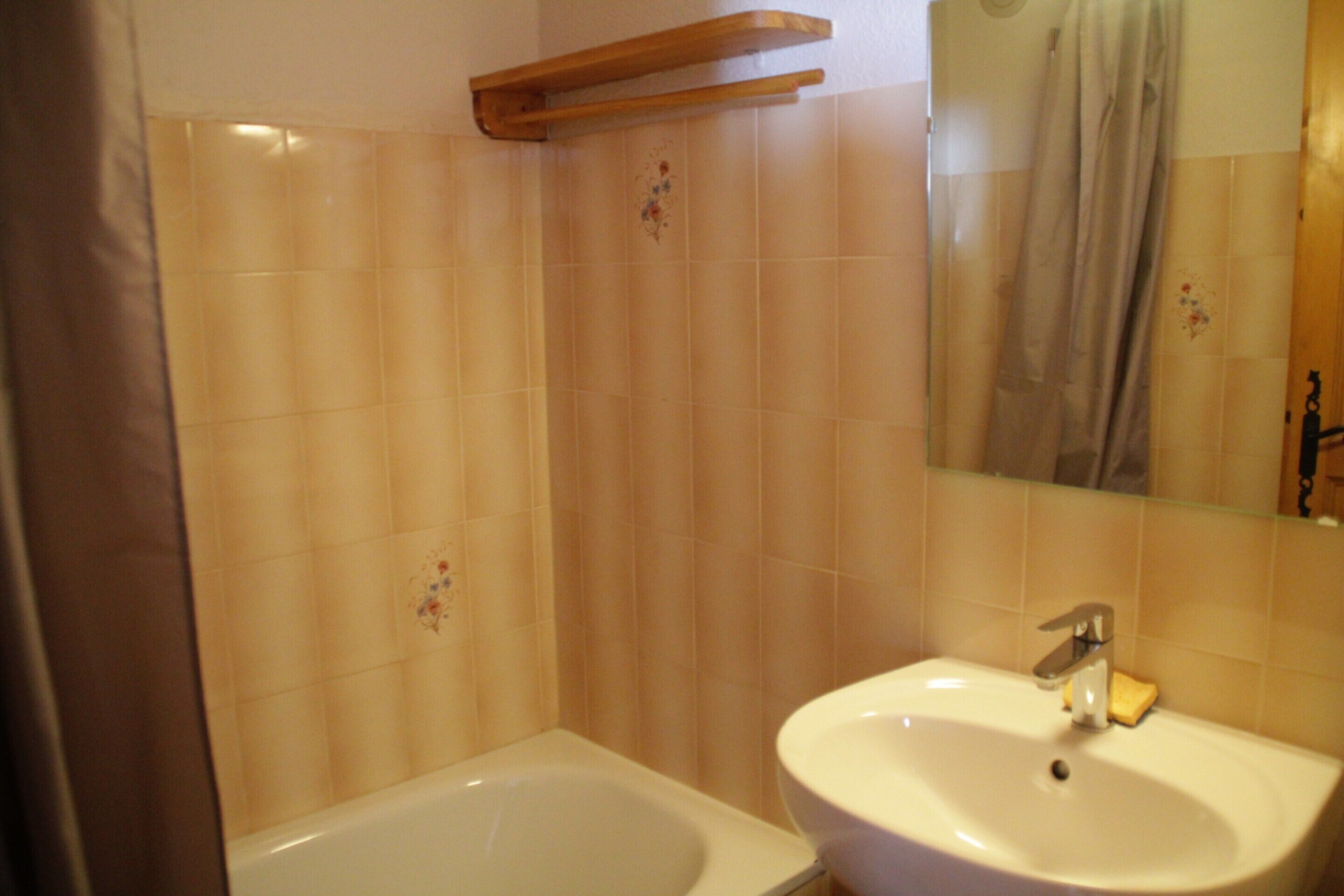 Un baño con bañera, lavabo y espejo.