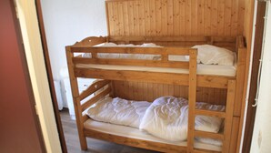 A bunk bed with two levels, wooden headboard, and white bedding. - Tavaillons Tv31 Swimming Pool & Center 4 Pers (Chatel)