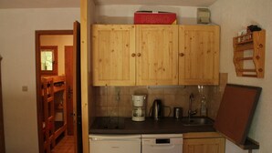 A compact kitchen with wooden cabinets, a dishwasher, a coffee maker, and a small countertop. - Voinettes Vnb2 Telecabine & Mountain 4 Pers (Chatel)
