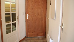 Una puerta de madera con marco blanco, un ventanal pequeño y un picaporte.