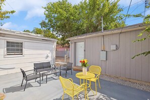 A patio area with outdoor furniture, a small table, and a flower vase. - Delightful 1BR 1BA Cozy Flat (Fort Worth)