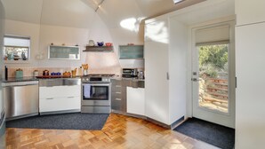 A modern kitchen with stainless steel appliances, a wooden floor, and a skylight. - Santa Fe Geo Dome w/ Trail Access & Views (Santa Fe)