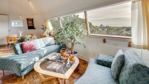 A spacious living room with a large window, a sofa, a coffee table, and a potted plant. - Santa Fe Geo Dome w/ Trail Access & Views (Santa Fe)