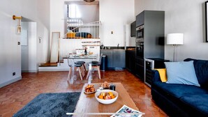 Un espacio habitable compacto con kitchenette, comedor y sofá.