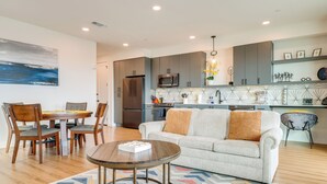 Ein modernes Wohnzimmer mit Sofa, Couchtisch und Essbereich.