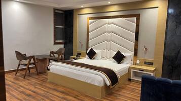 A modern hotel room with a large bed, a desk, and a chair.