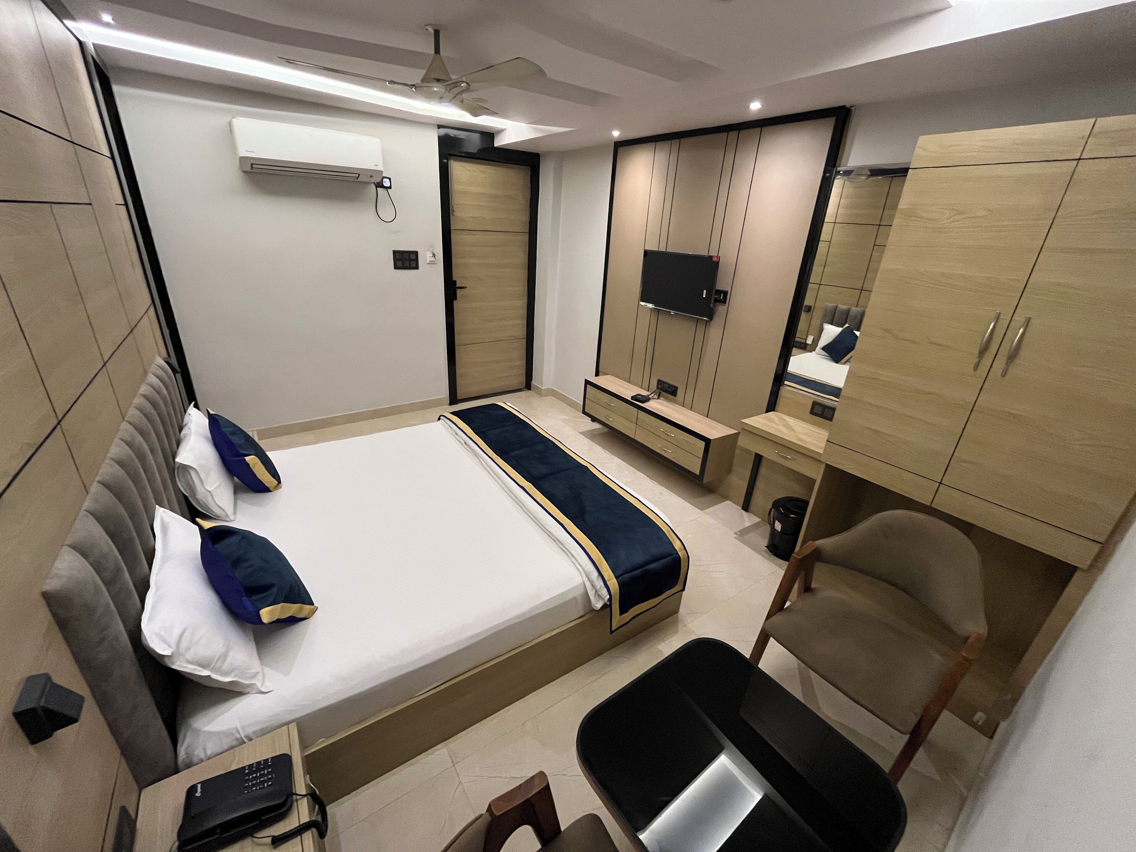 A modern bedroom with a bed, a desk, a chair, and a wardrobe.